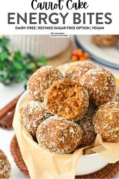 carrot cake energy bites in a white bowl on top of a wooden table with oranges and