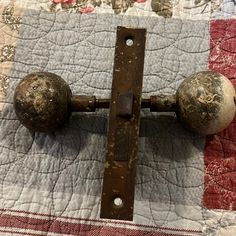 an old door handle with two knobs on top of a quilted table cloth