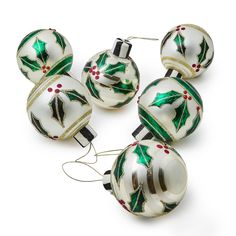 six glass christmas ornaments with holly designs on them