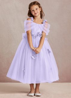 Shaylee is an enchanting A-line flower girl dress that is crafted from delicate tulle. She features intricately handmade 3D flower embellishments. Off-shoulder sleeves offer a touch of whimsy that is complimented with a tulle bow back. The flowers cascade gracefully down the tulle skirt that flows with every step. Dusty Purple Dress, Lilac Flower Girl Dresses, Purple Flower Girls, Purple Flower Girl Dress, Taylor Outfits, Tulle Bow, Flower Embellishments, Tulle Flower Girl, Tulle Bows