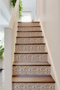 the stairs are painted with blue and gold floral wallpaper, along with wooden handrails