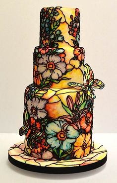 a multi - tiered cake decorated with flowers and butterflies