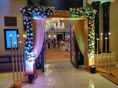 an entrance to a banquet hall decorated with flowers and candles