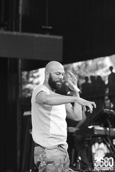 a man standing on top of a stage holding his hands out to the side while singing