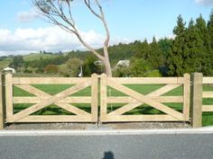 a wooden fence in front of a grassy field