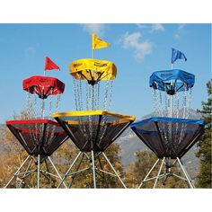 four different colored kites on top of each other with flags flying in the air