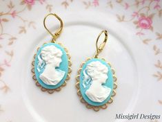 These beautiful Cameo earrings were created with 18x25mm brass scalloped settings adorned with 18x25mm Aqua blue cameo cabochons and brass lever back ear wires. These gorgeous earrings hang beautifully from lever back ear wires and measure 1 3/4 inches in length and 3/4 inches in width. These earrings are very romantic and chic...You will truly enjoy these for many years to come. *All of my listings are handmade with love and ready to ship and will arrive to you in a gift box with bow for easy g Blue Cameo Jewelry For Wedding, Turquoise Jewelry With Ear Wire For Wedding, Vintage Blue Clip-on Earrings For Gift, Turquoise Wedding Jewelry With Ear Wire, Cameo Drop Earrings As Gift, Cameo Drop Earrings Jewelry Gift, Gift Cameo Drop Earrings Jewelry, Turquoise Pierced Earrings For Wedding, Turquoise Clip-on Earrings As Gift