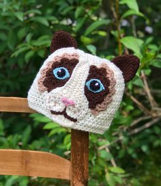 a crocheted cat hat sitting on top of a wooden chair