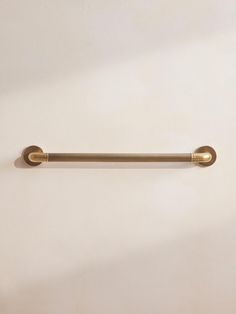 an image of a brass colored handle on a white wall with no one around it