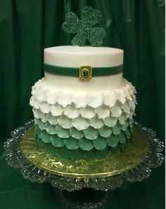 a three tiered cake with white and green frosting