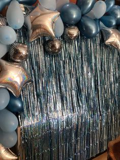 balloons and streamers are arranged in the shape of a star on a silver table cloth