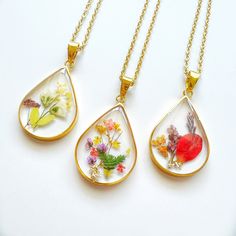 Introducing our stunning Birth Month Flower Teardrop Necklace, a captivating piece of jewelry that elegantly showcases the beauty of nature. Each pendant features a meticulously chosen pressed dried flower encased within a circle resin bezel, creating a mesmerizing centerpiece. Handcrafted with care, every necklace is a unique work of art, reflecting the individuality found in nature's wonders. To ensure both beauty and durability, the necklace bezel are skillfully plated with 18k gold on copper Botanical Flower Jewelry With Natural Inclusions, Bohemian Birth Flower Pendant Necklace, Bohemian Jewelry Birth Flower Pendant, Bohemian Dangle Jewelry With Pressed Flowers, Nature-inspired Birth Flower Necklace, Bohemian Pendant Necklaces With Pressed Flowers, Nature-inspired Flower Jewelry With Pressed Flowers, Handmade Teardrop Necklace In Nature-inspired Style, Handmade Teardrop Necklace With Nature-inspired Style