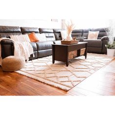 a living room filled with lots of furniture and decor on top of a hard wood floor