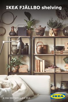 a living room filled with lots of furniture and plants on top of bookshelves