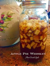 apple pie whiskey in a glass jar on a counter top next to a canister