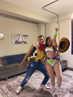 a man and woman dressed up in costumes posing for the camera with one holding a cowgirl's hat