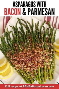 asparagus spears are arranged on a plate with lemon slices and seasoning sprinkles