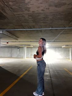 a woman standing in an empty parking garage