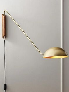 a wall mounted lamp with a wooden arm and light bulb attached to the back of it