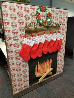 an office cubicle decorated for christmas with stockings on the fireplace