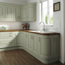 an image of a kitchen setting with white cabinets and wood counter tops on the island