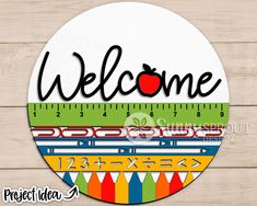 a wooden sign that says welcome with an apple on it and the word, teacher