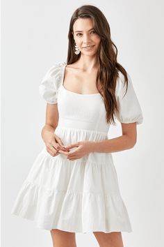 This white mini dress is crafted from breathable cotton for all-day comfort. It features an open back with double bow detail and puff sleeves for a charming, feminine look. Its tiered style provides a flattering silhouette. Square neckline Short puff sleeves Side pockets Adjustable bodice 100% Cotton Lined By Mustard Seed Size Guide BUST, S: 32-33" M:34-35" L: 36-37" WAIST, S: 25-26" M: 27-28" L: 29-30" The model is wearing a size Small Model Specs, Height 5'9" Bust 32" Waist 24" Hips 34" Dress Cottagecore, Usa Dresses, Grad Dresses, Puffed Sleeves Dress, Woven Dress, Tie Dress, Tiered Dress, Sheer Fabrics, White Mini Dress