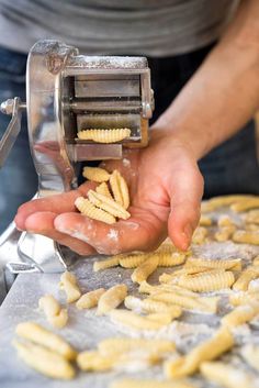 a person is using a pasta machine to make pasta