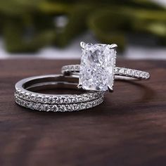 an engagement ring set with a princess cut diamond surrounded by pave diamonds on a wooden surface