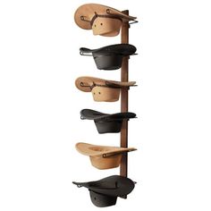 a wall mounted hat rack with four hats on it and three leather hats hanging from the top