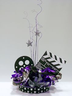 a small black and white basket with purple ribbons, film reel, and star decorations