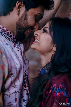 a man and woman standing next to each other with their faces close together, smiling