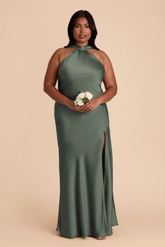 a woman in a long green dress posing for the camera with her hands on her hips