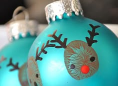 two blue christmas ornaments with reindeer noses on them