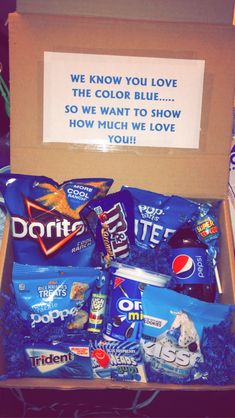 an open box filled with snacks on top of a table next to a sign that reads, we know you love the color blue so we want to show how much we love you