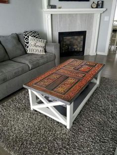 a living room with a couch, coffee table and fire place in the middle of it