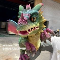 a man holding a toy dragon in his hand