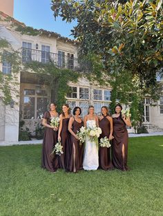 a group of women standing next to each other in front of a building