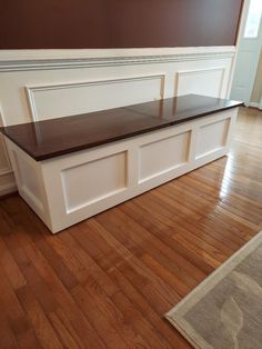 a white bench sitting on top of a hard wood floor