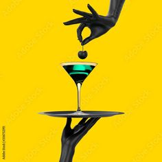 a hand holding a tray with a martini glass on it and another hand reaching for the drink