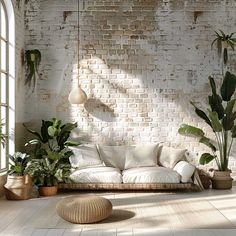 a living room filled with lots of plants next to a white brick wall and floor