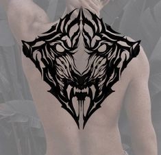 the back of a man's body with an intricate tattoo design on his back