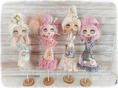 three little doll figurines sitting on top of each other in front of a wooden wall