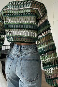 a woman wearing jeans and a green sweater