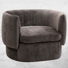 a gray chair sitting in front of a white wall