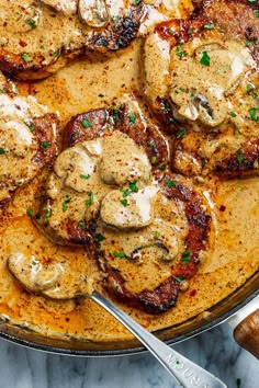 a pan filled with meat covered in sauce and mushrooms