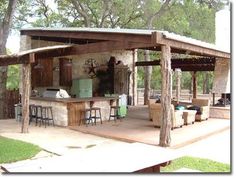 an outdoor kitchen is built into the side of a building with bars and stools