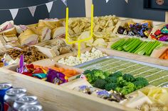 a table filled with lots of different types of food and snacks on it's trays