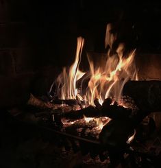 a fire burning in a fireplace with lots of flames