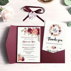 the wedding stationery is set on top of a table with flowers and greenery